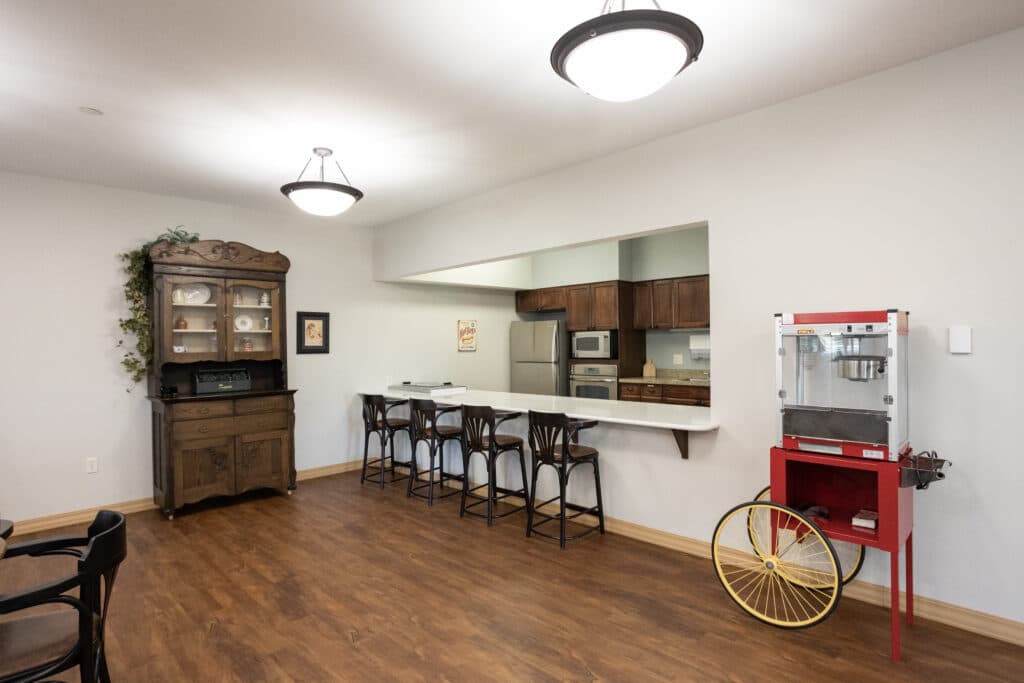 Community room with mini kitchen and popcorn machine.