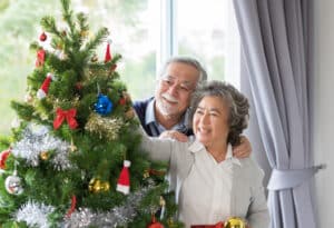 A senior couple decorating a tree for the holidays