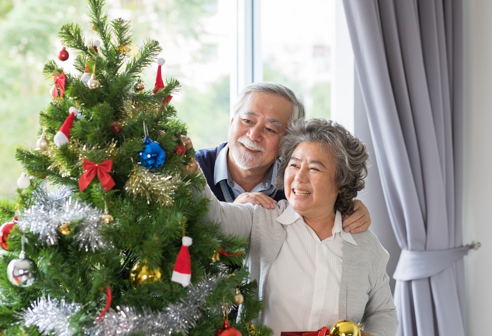 A senior couple decorating a tree for the holidays