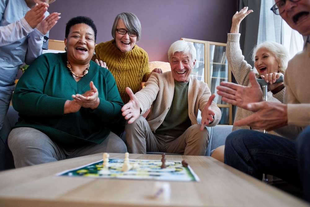 A group of seniors playing a board game at the best Elkhorn memory care community