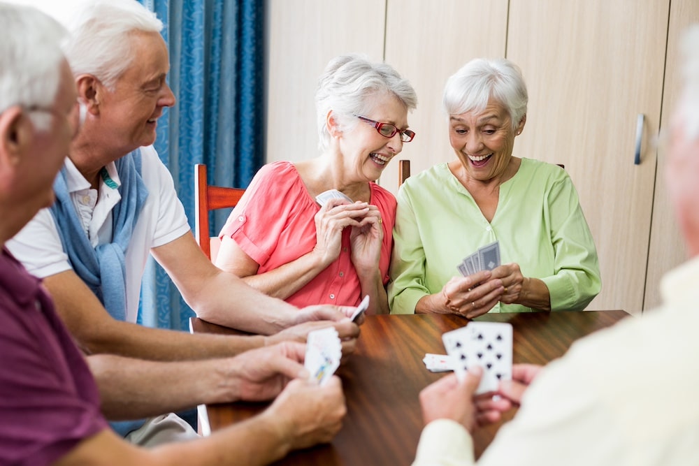 A group of senior friends playing cards and laughing