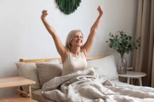 A senior woman yawning and stretching awake